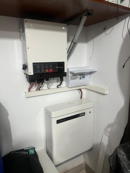 Inversor y bateria marca Goodwe Controlador eléctrico montado en pared con un pequeño armario y un dispositivo debajo.