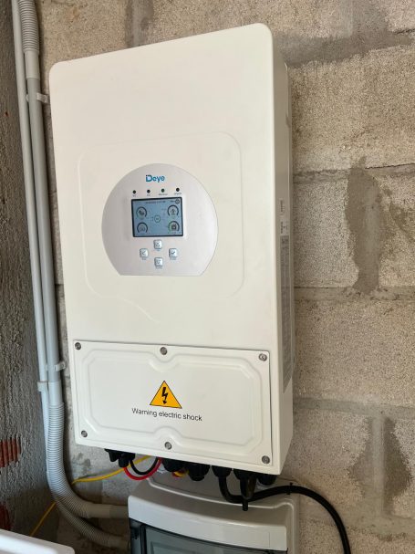 Inversor Deye Controlador solar montado en la pared, con pantalla y conexiones eléctricas.
