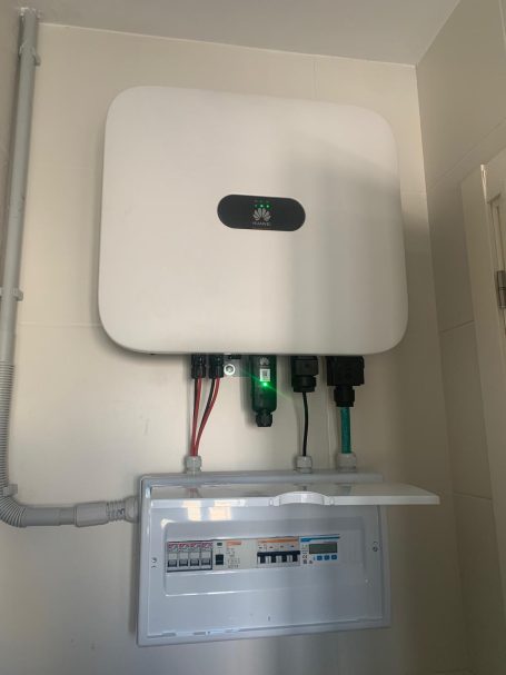 Inversor Huawei Dispositivo eléctrico montado en la pared con conexiones y un panel de control abajo.