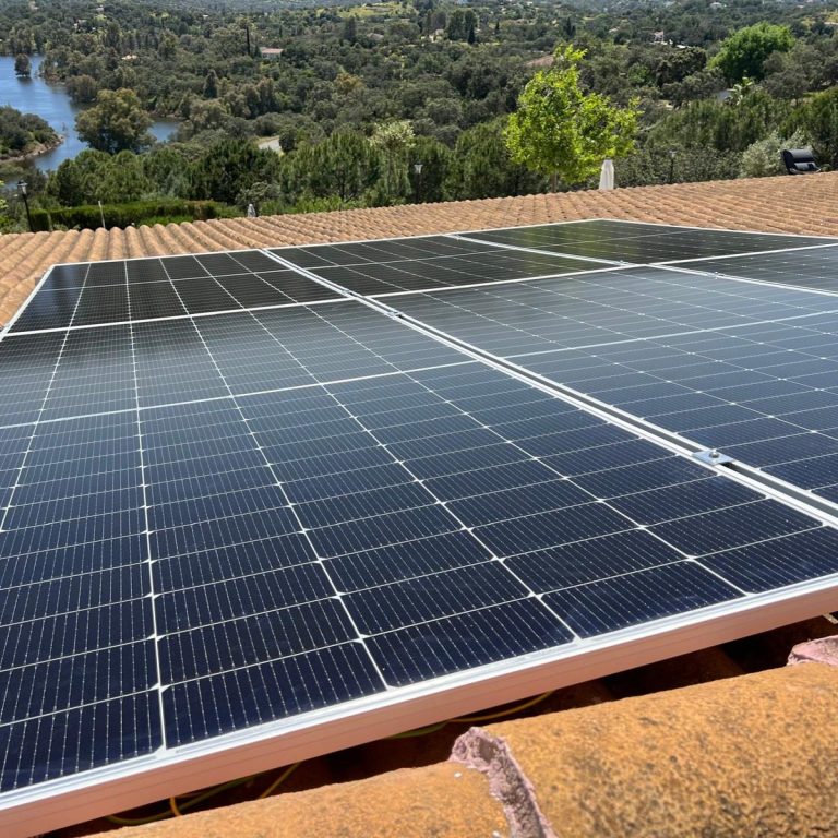 Placas solares fotovoltaicas Paneles solares instalados en una azotea con vista a un lago.